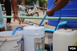 ពលរដ្ឋ​រស់នៅ​ក្នុង​បុរី​មួយនៅសង្កាត់​សំរោង​ក្រោម​ ខណ្ឌ​ពោធិ៍​សែន​ជ័យ រាជ​ធានី​ភ្នំពេញ កំពុង​បង្ហូរ​ទឹក​ពី​បាសាំង​ទឹក ដាក់​ធុង​សម្រាប់​ប្រើប្រាស់ នាថ្ងៃ​ទី​៩ ខែ​កុម្ភៈ ឆ្នាំ​២០២២។ (កាន់ វិច្ឆិកា/វីអូអេ)