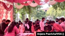 Voters check their name in electoral list as polls open in Uttar Pradesh, India's most populous and politically significant state, Feb. 10. 2022.