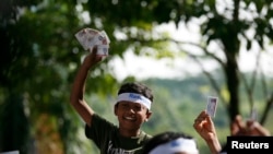A refugee from Myanmar shows refugee status cards during a demonstration outside the United Nations High Commissioner (UNHCR) office in Kuala Lumpur Dec. 3, 2008.