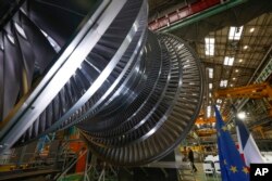 The European Union and French National flags are seen next to a nuclear turbine at the GE Steam Power System site, in Belfort, eastern France, Feb. 10, 2022.