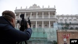 A cameraman films the Hotel Palais Coburg, venue of the meeting of the Joint Comprehensive Plan of Action (JCPOA), in Vienna, Feb. 8, 2022.