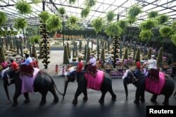 Beberapa pasang pengantin menikah sekaligus merayakan Hari Valentine di atas punggung gajah, di Taman Tropis Nong Nooch di provinsi Chonburi, Thailand, 14 Februari 2021. REUTERS/Chalinee Thirasupa