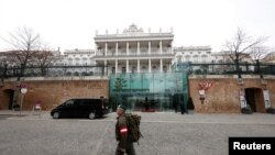 FILE - A member of Austrian armed forces walks past Palais Coburg, the site of a meeting of the Joint Comprehensive Plan of Action, in Vienna, Austria, Feb. 8, 2022. 