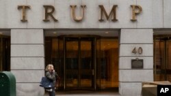 Seorang perempuan tampak berjalan melewati gedung Trump di area distrik keuangan New York, pada 13 Januari 2021. (Foto: AP/Mark Lennihan)