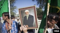 Para pendukung Burhanuddin Rabbani membawa foto almarhum di luar rumahnya, sehari setelah terjadinya pembunuhan (21/9). Rabbani dibunuh oleh pembom bunuh diri yang membawa pesan perdamaian palsu.