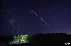 FILE - This time-exposure image shows a trail of a group of SpaceX's Starlink satellites passing over Uruguay, some 185 km north of Montevideo, Feb. 6, 2021. Up to 40 SpaceX high-speed internet satellites were knocked out of orbit by a geomagnetic storm shortly after launch.