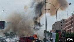 Regu pemadam kebakaran berusaha memadamkan kobaran api akibat serangan bom di Abuja, Nigeria pekan lalu.