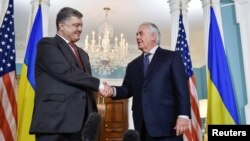 FILE - U.S. Secretary of State Rex Tillerson shakes hands with Ukrainian President Petro Poroshenko during their meeting at the U.S. State Department in Washington, June 20, 2017. Tillerson and a new special representative will visit Ukraine Sunday.