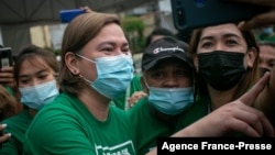 Sara Duterte, left, mayor and daughter of outgoing Philippines President Rodrigo Duterte, poses for a selfie with city hall employees in Davao on Nov. 9, 2021.