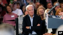 Democratic presidential candidate former Vice President Joe Biden waits to speak to local residents during a bus tour stop, Dec. 3, 2019, in Mason City, Iowa. 