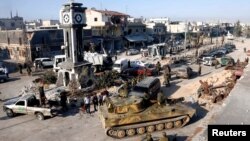 Tentara yang loyal pada rezim Suriah dengan tank-tank militer mereka di Qusair, setelah angkatan darat Suriah mengambil alih kota itu dari pemberontak (5/6). (Reuters/Mohamed Azakir)