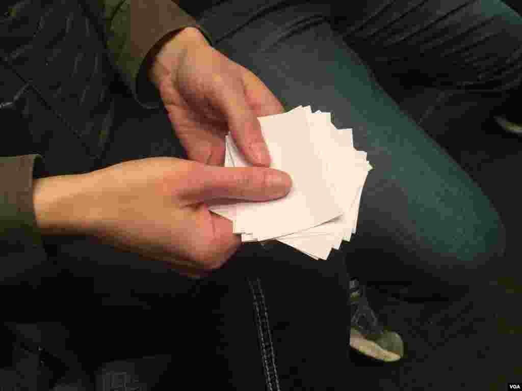 A Republican caucus voter collects ballots after voting at a West Des Moines caucus site, Iowa, Feb. 1, 2016. (K. Farabaugh/VOA) 
