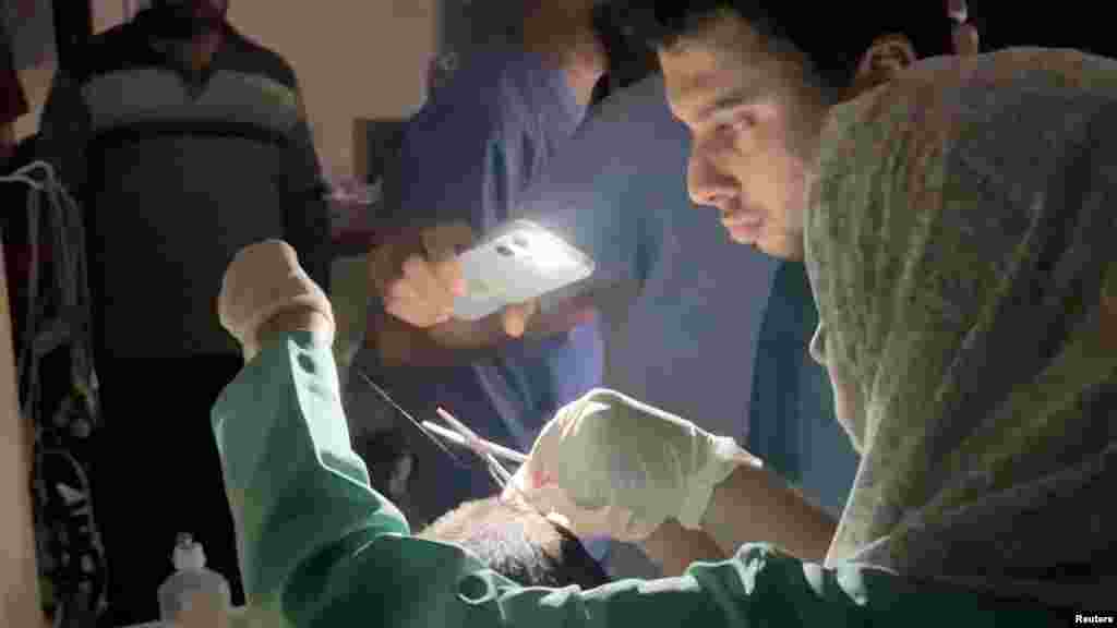 Madaktari wajaribu kumtibu mgonjwa wakitumia mwangaza kutoka simu ya mkononi katika hospitali ya Indonesia, mjini Gaza.