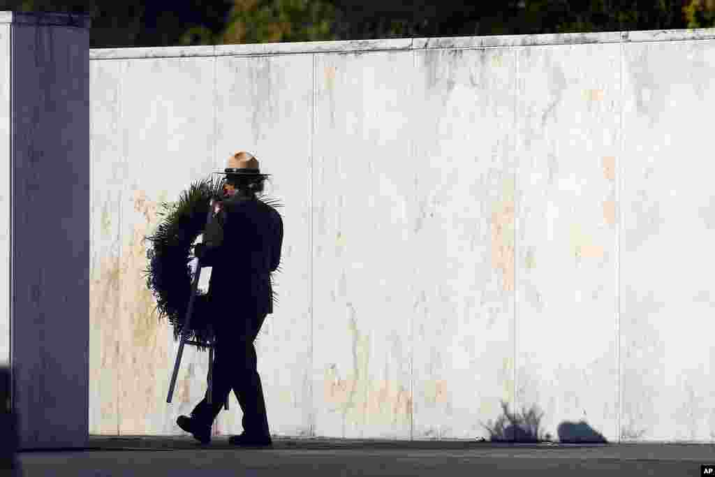 A member of the National Park Service brings a wreath out to the crash site at the Flight 93 National Memorial on the 23rd anniversary of the terror attacks in Shanksville, Pennsylvania, Sept. 11, 2024.