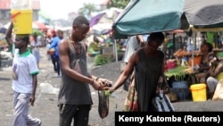 Un Congolais fait des achats au marché de Kinshasa, RDC, le 28 mars 2020.