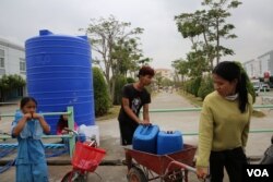 ពលរដ្ឋ​រស់នៅ​ក្នុង​បុរី​មួយនៅសង្កាត់​សំរោង​ក្រោម​ ខណ្ឌ​ពោធិ៍​សែន​ជ័យ រាជ​ធានី​ភ្នំពេញ កំពុង​បង្ហូរ​ទឹក​ពី​បាសាំង​ទឹក ដាក់​ធុង​សម្រាប់​ប្រើប្រាស់ នាថ្ងៃ​ទី​៩ ខែ​កុម្ភៈ ឆ្នាំ​២០២២។ (កាន់ វិច្ឆិកា/វីអូអេ)