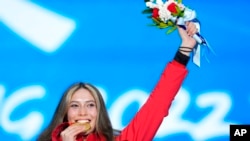 Gold medalist Eileen Gu of China celebrates during the medal ceremony for the women's freestyle skiing big air at the 2022 Winter Olympics, Feb. 8, 2022, in Beijing.