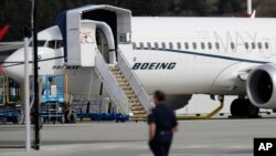 FILE - In this March 14, 2019, file photo, a worker walks next to a Boeing 737 MAX 8 airplane parked at Boeing Field in Seattle. Flyadeal, a Saudi budget carrier says it is ordering 30 new Airbus planes, replacing a $6 billion agreement it had with…