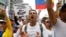 Demonstrators carry a sign – ' All the food for all the people! No more dictatorship' – while rallying against Venezuela's President Nicolas Maduro in Caracas, May 1, 2017.