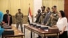 The leader of Sudan's transitional council looks on as military and civilian members of Sudan's new ruling body, the Sovereign Council, are sworn in at the presidential palace in Khartoum, Sudan, Aug. 21, 2019. 