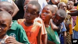 Anak-anak Haiti berbaris untuk menerima sepiring makanan di tempat penampungan keluarga yang mengungsi akibat kekerasan antargeng, di ibu kota Port-au-Prince.