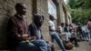 Des migrants du Zimbabwe et du Mozambique sont assis dans une rue de Johannesbourg, en Afrique du Sud, le 23 novembre 2017.