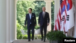 조 바이든(오른쪽) 미국 대통령과 윤석열 한국 대통령이 지난 26일 백악관 회담 직후 공동회견을 위해 로즈가든으로 이동하고 있다. (자료사진)