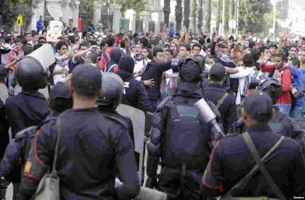 Cairo University students shout slogans against the military and Interior Ministry in front of riot police at the main gate of the university, Cairo, Nov. 24, 2013.