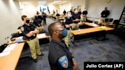 In this Sept. 9, 2020 photo, training police officers at the Baltimore Police Academy watch a video presentation during a class session on justice in Baltimore. (AP Photo/Julio Cortez)