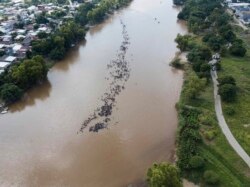 FILE - A group of Central American migrants bound for the U.S. border wade in mass across the Suchiate River, that connects Guatemala and Mexico, in Tecun Uman, Guatemala, Oct. 29, 2018.