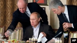2017年12月11日 普里戈津(左)为普京(中)上菜