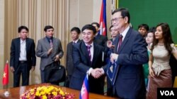 លោក​​ វ៉ា គឹមហុង​ សហ​ប្រធាន​គណៈ​កម្មការ​​ចម្រុះ​កិច្ចការ​ព្រំដែន​កម្ពុជា​វៀត​ណាម និង​​លោក​ Ho Xuan Son (ស៊ូ ស៊ានសឿន​) អនុរដ្ឋមន្ត្រី​ក្រសួងការ​បរទេស​វៀតណាម​​ក្នុង​​ពិធី​​​ចុះ​​ហត្ថលេខា​​លើ់​​ឯកសារ​​មួយ​​ចំនួន​​​នា​ទី​ស្តី​ការ​គណៈរដ្ឋមន្ត្រី​នៅ​ថ្ងៃ​ទី​០៩ ​ខែ​កក្កដា ​ឆ្នាំ២០១៥។ ​(នៅ វណ្ណារិន/VOA) 