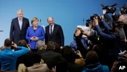 Kanselir Jerman Angela Merkel diapit Gubernur Bavaria Horst Seehofer (kiri) dan Ketua Demokratik Sosial Martin Schulz berpose untuk foto setelah pembicaraan pembentukan pemerintahan baru di Berlin, Jerman, 12 Januari 2018. 