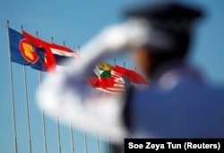Seorang petugas polisi berdiri di dekat bendera nasional negara-negara ASEAN selama KTT ASEAN ke-25 di Pusat Konvensi Internasional Myanmar di Naypyitaw, 12 November 2014. (Foto: REUTERS/Soe Zeya Tun)