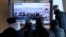 People watch a TV report on the crisis in Ukraine during a news program at the Seoul Railway Station, in Seoul, South Korea, Feb. 24, 2022.