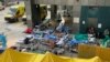 Patients wearing face masks lie in bed at a makeshift treatment area outside a hospital, following the COVID-19 outbreak in Hong Kong, Feb. 16, 2022. 