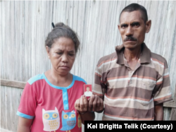 Brigitta Telik dan suaminya, Markus Ukat memegang foto anak mereka Klaudius Ukat. (Foto: Courtesy/Keluarga Brigitta Telik)