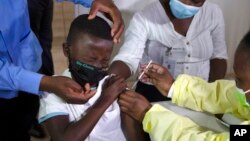 FILE - A child gets a vaccine against COVID-19 in Diepsloot Township near Johannesburg, Oct. 21, 2021.