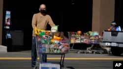 FILE - Shoppers exit a Costco Friday, Jan. 28, 2022, in Santa Clarita, Calif.