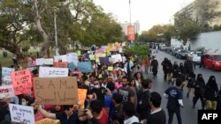 Para polisi perempuan tampak mengawal jalannya aksi yang dilakukan oleh para aktivis perempuan saat merayakan Hari Perempuan Internasional di Karachi, Pakistan, pada 8 Maret 2020. (Foto: AFP/Rizwan Tabassum) 