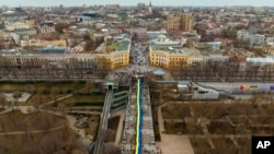 Demonstran menggelar pawai bendera besar Ukraina di sepanjang jalan di Odessa, Ukraina, Minggu, 20 Februari 2022. Indonesia masih terus berkoordinasi dan memantau secara cermat perkembangan di Ukraina. (Foto: AP)