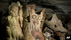 FILE - Pre-columbian artifacts sit in a cave at the Mayan ruins of Chichen Itza, Yucatan, Mexico, Tuesday, Feb. 19, 2019.