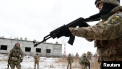 Serdadu pasukan pertahanan wilayah Ukraina berpartisipasi dalam latihan militer di luar wilayah ibu kota Kyiv, pada 29 Januari 2022. (Foto: Reuters/Valentyn Ogirenko)