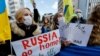 Warga Ukraina yang tinggal di Jepang memegang plakat dan bendera selama unjuk rasa mengecam Rusia atas tindakannya di Ukraina, dekat Kedutaan Rusia di Tokyo, Jepang 23 Februari 2022. (Foto: Reuters)