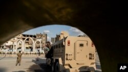 FILE - US-backed Syrian Democratic Forces (SDF) fighters stand guard at Al Naeem Square, in Raqqa, Syria, Feb. 7, 2022. 