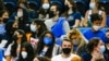 Fans wearing face masks watch a college basketball game in Los Angeles, Feb. 17, 2022.