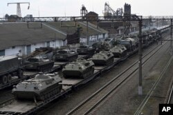 Kendaraan lapis baja Rusia dimuat ke platform kereta api di stasiun kereta api di wilayah tidak jauh dari perbatasan Rusia-Ukraina, di wilayah Rostov-on-Don, Rusia, Rabu, 23 Februari 2022. (Foto: AP)