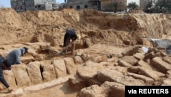 Men work in a newly discovered Roman cemetery in Gaza, in this handout photo obtained by Reuters, February 17, 2022. Ministry of Tourism and Antiquities/Handout via REUTERS 