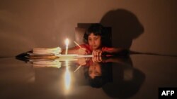 A child studies at her home during a power cut in Biyagama, a suburb of the capital Colombo, Sri Lanka, Feb. 2, 2022.