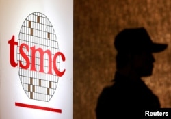 Seorang petugas keamanan berdiri di dekat logo Taiwan Semiconductor Manufacturing Co. Ltd (TSMC) selama konferensi investor di Taipei. (Foto: REUTERS/Pichi Chuang)